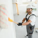 repair-worker-paints-a-white-w